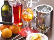 Bebida italiana tradicional Aperol Spritz na mesa com laranjas e azeitonas — Fotografia de Stock