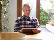 Older man using tablet computer — Stock Photo