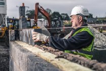 Arbeiter verlegen Ziegel auf Baustelle — Stockfoto