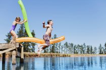 Bambini che saltano nel lago dal molo — Foto stock