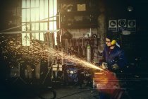 Welder cutting iron in workshop interior — Stock Photo