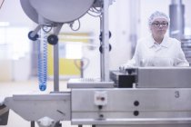Operaio di fabbrica che gestisce macchinari per la produzione alimentare — Foto stock