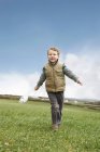 Junge läuft mit Windmühle — Stockfoto