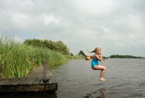 Menina pulando no lago rural — Fotografia de Stock