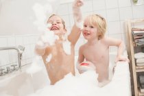 Irmãos brincando com sabonetes na banheira — Fotografia de Stock