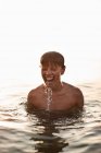 Adolescent garçon jouer dans l 'eau — Photo de stock