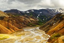 Річкова долина і засніжені різнокольорові гори — стокове фото