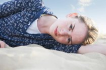 Adolescente deitado na areia da praia — Fotografia de Stock
