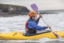 Jeune femme kayak dans la mer — Photo de stock