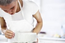 Крупним планом жінка прикрашає торт — стокове фото