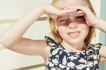Criança cobrindo seus olhos do brilho do sol — Fotografia de Stock