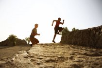 Dos amigos varones corriendo juntos, al aire libre - foto de stock