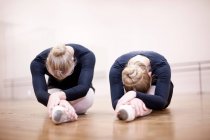 Ballerinas stretching on studio floor — Stock Photo