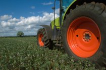 Traktor fährt durch Feldfrüchte — Stockfoto