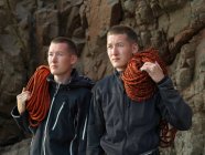 Homens carregando laços de corda na praia — Fotografia de Stock