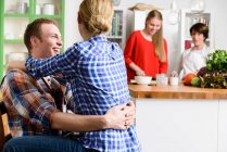 Young couple in kitchen with woman and teenage girl — Stock Photo