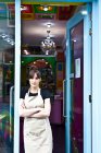 Retrato de trabalhadora na loja de bolos, em pé na porta da loja, olhando para fora — Fotografia de Stock