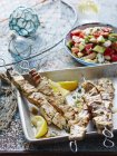 Swordfish souvlaki and vegetable salad on table — Stock Photo