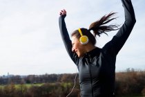Жінка в навушниках танцює на відкритому повітрі — стокове фото