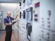 Ingeniero inspeccionando simulador de sala de control de central nuclear - foto de stock