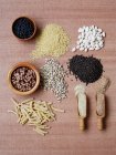 Dried pulses and grains in bowls and wooden spoons — Stock Photo