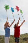 Mädchen halten Windmühlen in den Himmel — Stockfoto