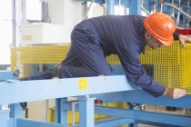Trabajador masculino comprobando cables en planta industrial - foto de stock