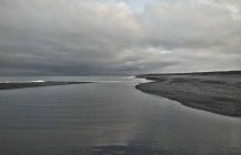 Lago con orillas vacías y nubes - foto de stock
