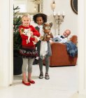 Girls holding dogs by Christmas tree — Stock Photo