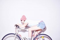 Молодая женщина наклоняется вперед на велосипеде — стоковое фото