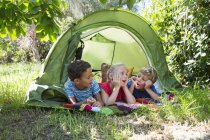 Three children chatting in garden tent — Stock Photo