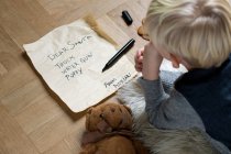 Мальчик пишет рождественский список для Санты — стоковое фото
