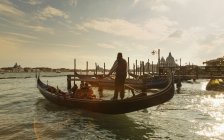 Silhouetted view of gondolier at sunset, Venice, Veneto, Italy — Stock Photo