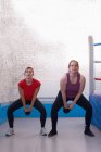 Frau trainiert mit Trainer im Fitnessstudio — Stockfoto