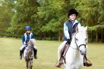 Two girls riding their ponies — Stock Photo