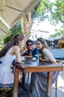 Female friends outdoors at cafe together — Stock Photo