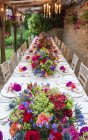 Diminishing perspective view of long table decorated with flowers — Stock Photo