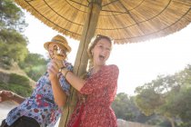 Pareja bajo sombrilla sosteniendo conos de helado, Mallorca, España - foto de stock