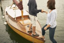 Чоловік допомагає жінці на старому човні — стокове фото