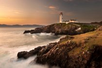 Lighthouse on foggy coastline — Stock Photo