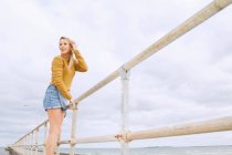 Junge Frau steht auf Seebrücke — Stockfoto