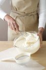 Woman mixing cream in bowl — Stock Photo