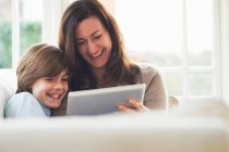 Mutter und Sohn auf dem Sofa mit digitalem Tablet — Stockfoto