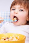Bambina essere cucchiaio-alimentato in seggiolone — Foto stock