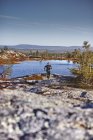 Sendero del hombre que corre a orillas del lago, Sarkitunturi, Laponia, Finlandia - foto de stock