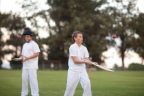 Garçons pratiquant frapper balle de cricket avec chauve-souris — Photo de stock
