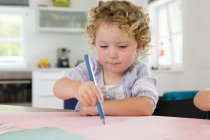 Girl drawing with pencil by table — Stock Photo