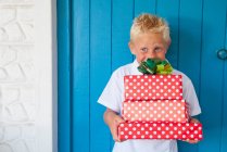 Boy excited holding gifts — Stock Photo