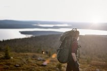 Hiker with backpack overlooking mountains, Lapland, Finland — Stock Photo