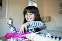 Mädchen verpackt Geschenke am Schreibtisch — Stockfoto